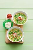 Pea and potato soup with sour cream and diced bacon