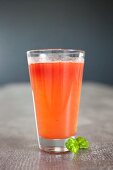 A cocktail made out of fresh vegetable and fruit juice (carrots, orange and beetroot)