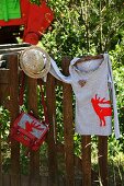 Shirt & Umhängetasche mit appliziertem rotem Hirschmotiv an Holzzaun aufgehängt