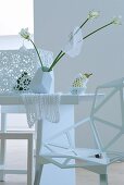 Tischdekoration in Weiß mit Blumen und Spitzendeckchen