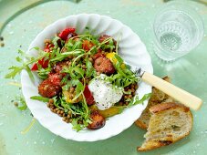 Salsiccia with red lentils, rocket and tomatoes
