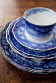 A stack of blue and white plates with a cup on top