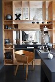Stilvoller Homeofficeplatz mit Designer-Holzschalenstuhl und elegantem eingebautem Raumteilerregal