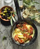 Tomatenrührei mit Zwiebeln, schwarze und grüne Oliven, Olivenöl, Olivenzweig, Oliven-Ciabatta und Lavendel