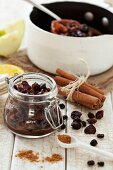 Homemade mince meat with cinnamon, ground spices and dried fruit in a pan and in a jar