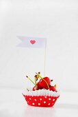 Red cherries in a paper paste decorated with a flag and a heart