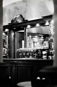 The interior of an Italian bar with a mirror and an espresso machine