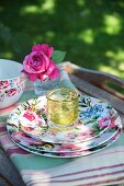 Stacked floral plates on striped tea towels in garden