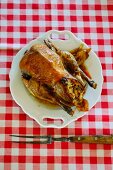 A stuffed roast chicken on a plate