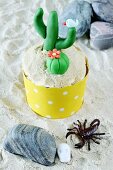 A lemon cupcake decorated with a cactus
