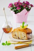 Lemon cake with fresh mint and honey in front of a flower pot