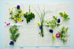 Various herbs and edible flowers on a cloth
