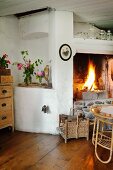 Corner of rustic interior with blazing fire in open fireplace