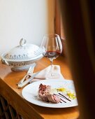 Roulade vom Wildschwein mit Fenchel, Orangengelee und Olivensauce auf Tisch (Restaurant Da Caino, Chefköchin Valeria Piccini)