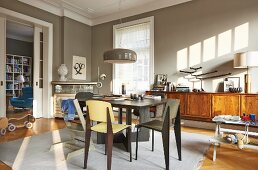 Dining room in warm grey with long, wooden sideboard and view into library