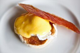 A bird's-eye view of eggs Benedict with a slice of crispy Parma ham