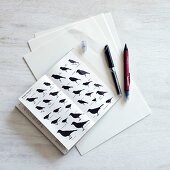 Zeichenstifte neben Buch mit verschiedenen Abbildungen von Vögeln
