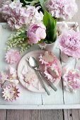 Rosenblütenplätzchen, Pfingstrosen Maiglöckchen und Hortensienblüten, auf weißem Holztablett