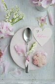 Heart-shaped name tag, rose-petal biscuits and spoon decorated with lily-of-the-valley on plate