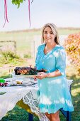 Woman serving braised leg of lamb at table in garden