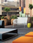 Seating area with designer furnishings and planters made form hollowed-out tree trunks on loft terrace in Johannesburg, South Africa