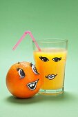 An orange and a glass of orange juice with faces