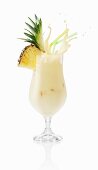 A pina colada splashing out of the glass