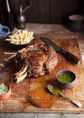 A rack of beef ribs with chimichurri sauce and chips
