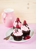 Chocolate cupcakes with raspberry cream and chocolate sauce