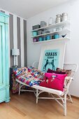 Patchwork blanket, cushions and framed circus poster on wicker bench below pots on floating shelves; accent wall with wide, pale grey stripes