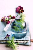 A vase of tufted pansies and fennel leaves