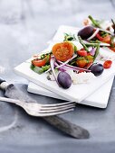 Kabeljausalat mit Zwiebel, Oliven und Tomaten