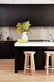 Kitchen with brown cupboards & island counter with wooden stools