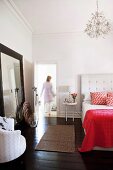 Double bed with upholstered headboard in bedroom with dark wooden floor