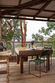 Old table and simple metal chairs wooden terrace