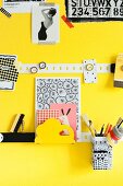 Metal strips and small magnets used as magnet pin board on yellow wall