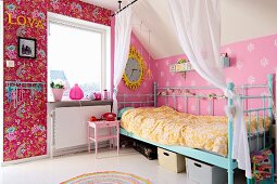 Retro Metallgitterbett in Türkis vor rosa tapezierter Wand in nostalgischem Mädchenzimmer