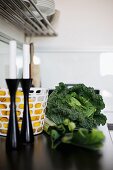 Vegetables and black candlesticks in front of basket of lemons