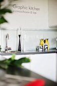 Detail of kitchen counter with sink and group of candlesticks to one side