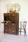 Vintage, dark wood bureau and chair against wall in rustic foyer