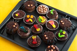 Various chocolate cupcakes decorated with sweets for Halloween