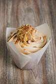 A cupcake topped with buttercream and caramel sauce
