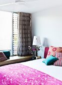Patterned bedspread on double bed in modern bedroom