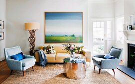 Fifties armchair, modern chrome coffee table and standard lamp with wooden base next to sofa in rustic living room