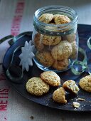 Ginger and almond biscuits in a screw-top jar and on a black plate