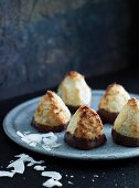 Chocolate-dipped coconut macaroons on a grey plate