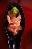 Wasabi and pickled pink ginger on a black an oriental spoon
