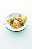 Fish fillet topped with potato served with a carrot medley