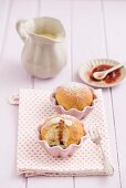 Buchteln (baked, sweet yeast dumplings) in muffin dishes with vanilla sauce and strawberry jam
