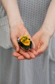 A hand holding vegetarian sushi